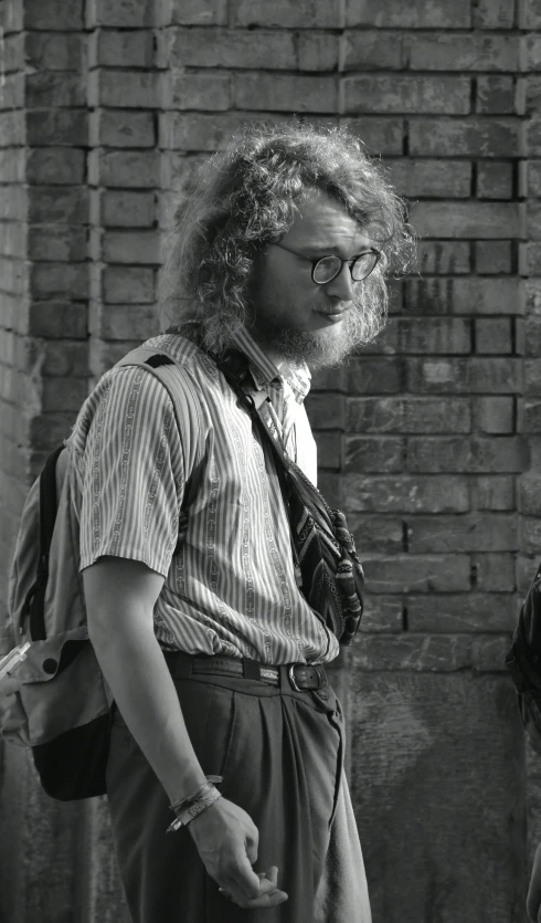 a man with curly hair standing outside