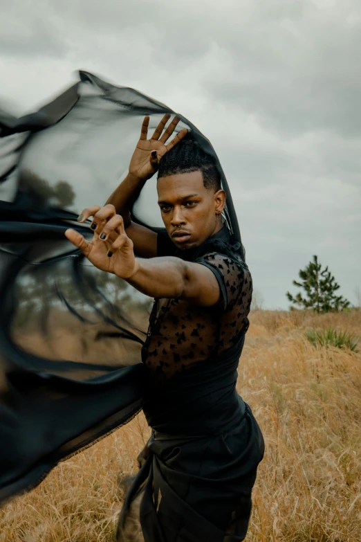 a man is dancing in a field holding an umbrella