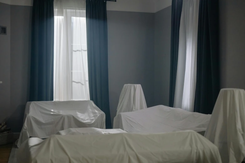 an unmade bed in a bedroom covered by sheet covering