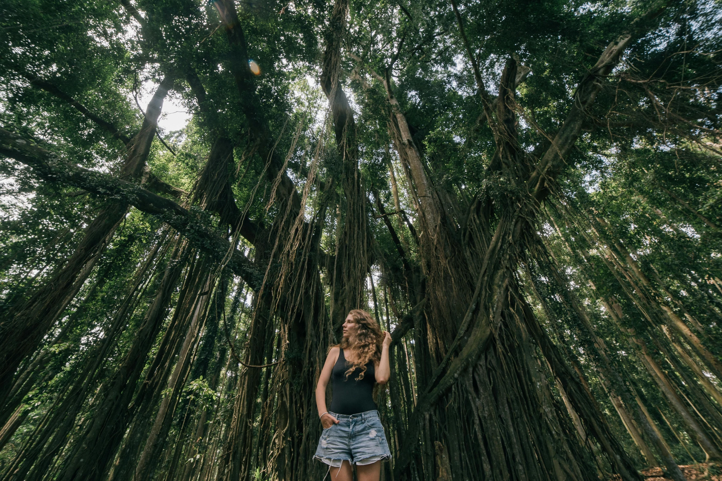 a woman standing in front of a group of trees