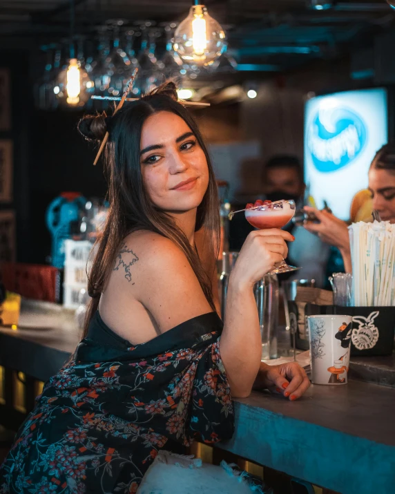 the woman in the dark dress has a drink with a bow around her neck