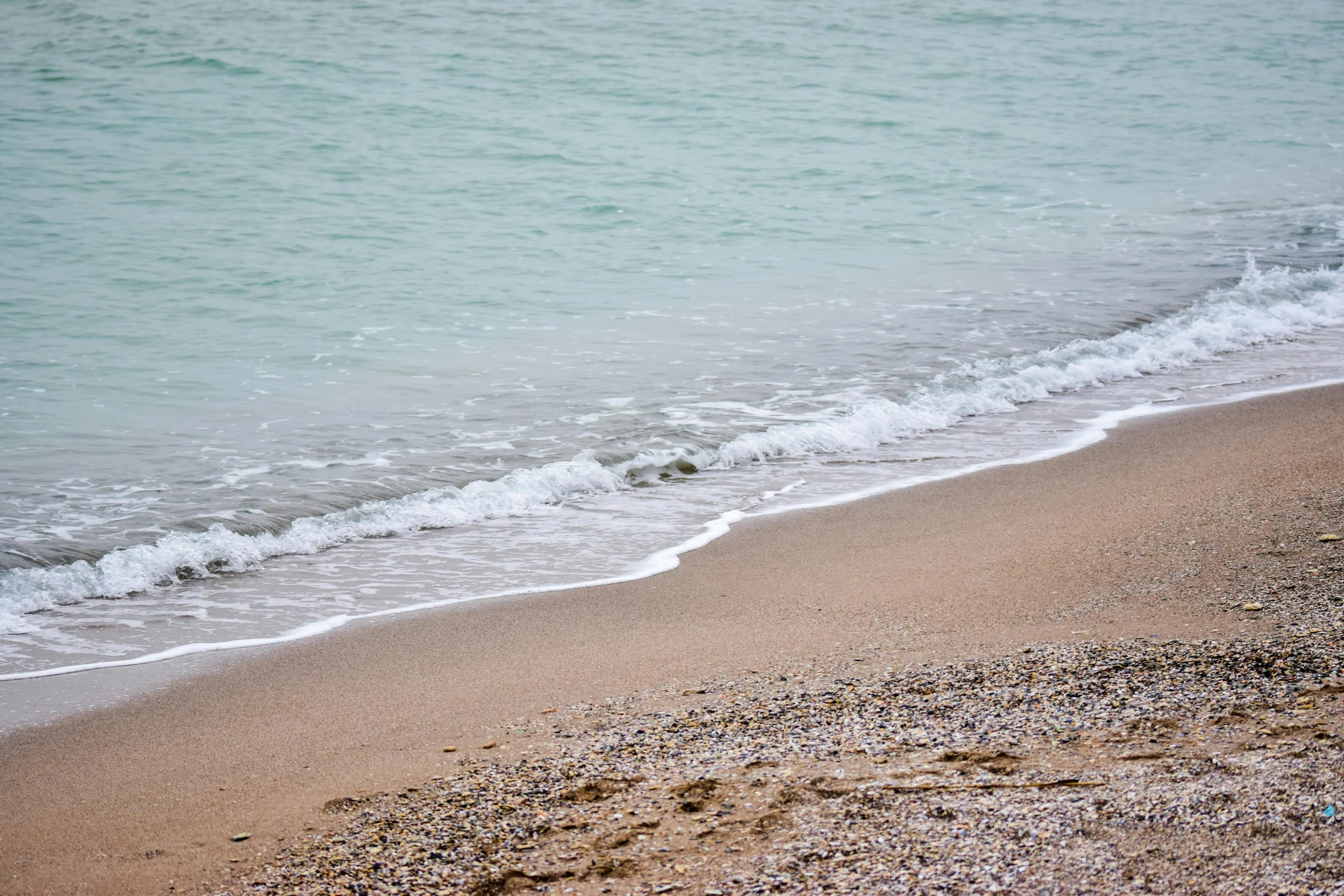 a beach with an ocean view and waves coming in