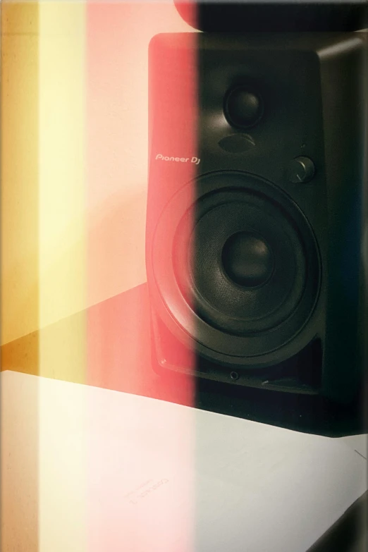 black speaker standing next to a multicolored background