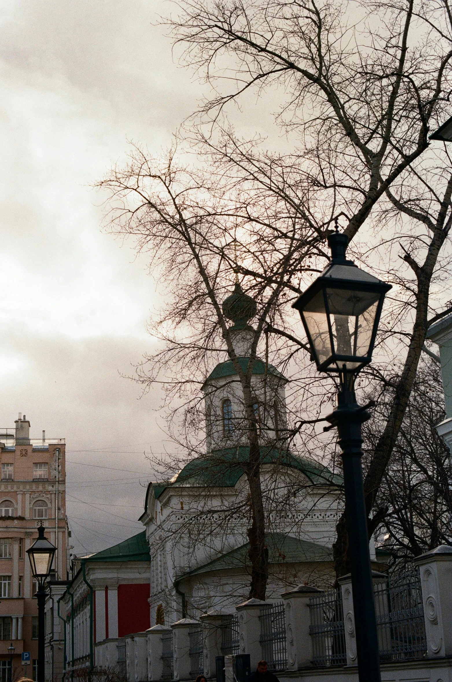 people and a street light on a cloudy day