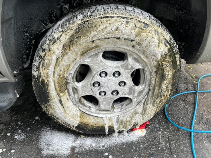 dirty rim with snow and mud on the side of a road