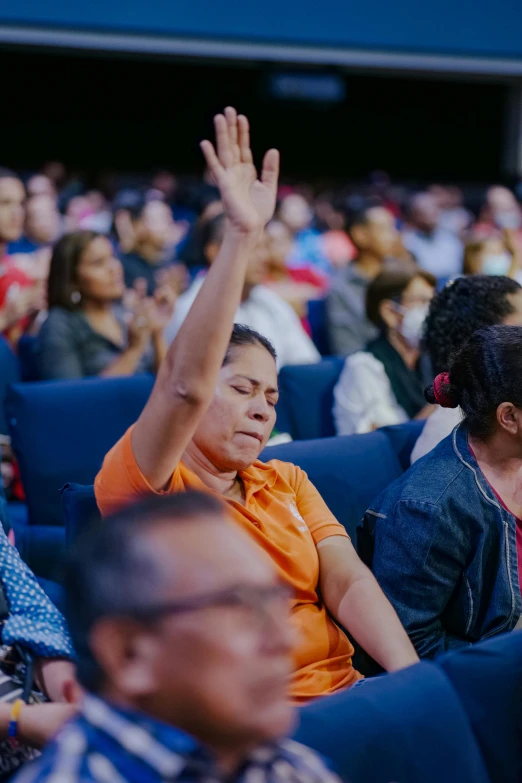 many people in the theatre clap and wave their hands