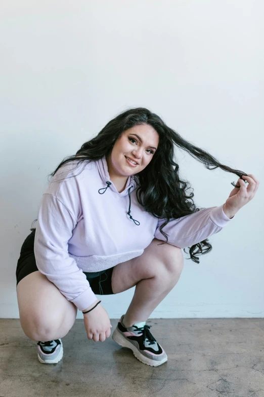 a woman squatting down and wearing sneakers