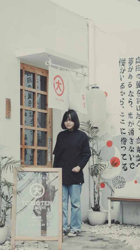 a woman wearing black standing in front of a building