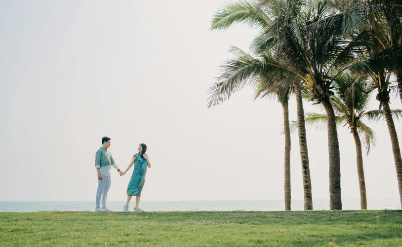 an older couple stands next to palm trees