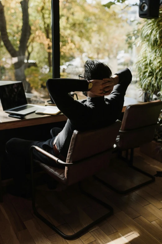 a woman is sitting in a chair and holding her face up to the side