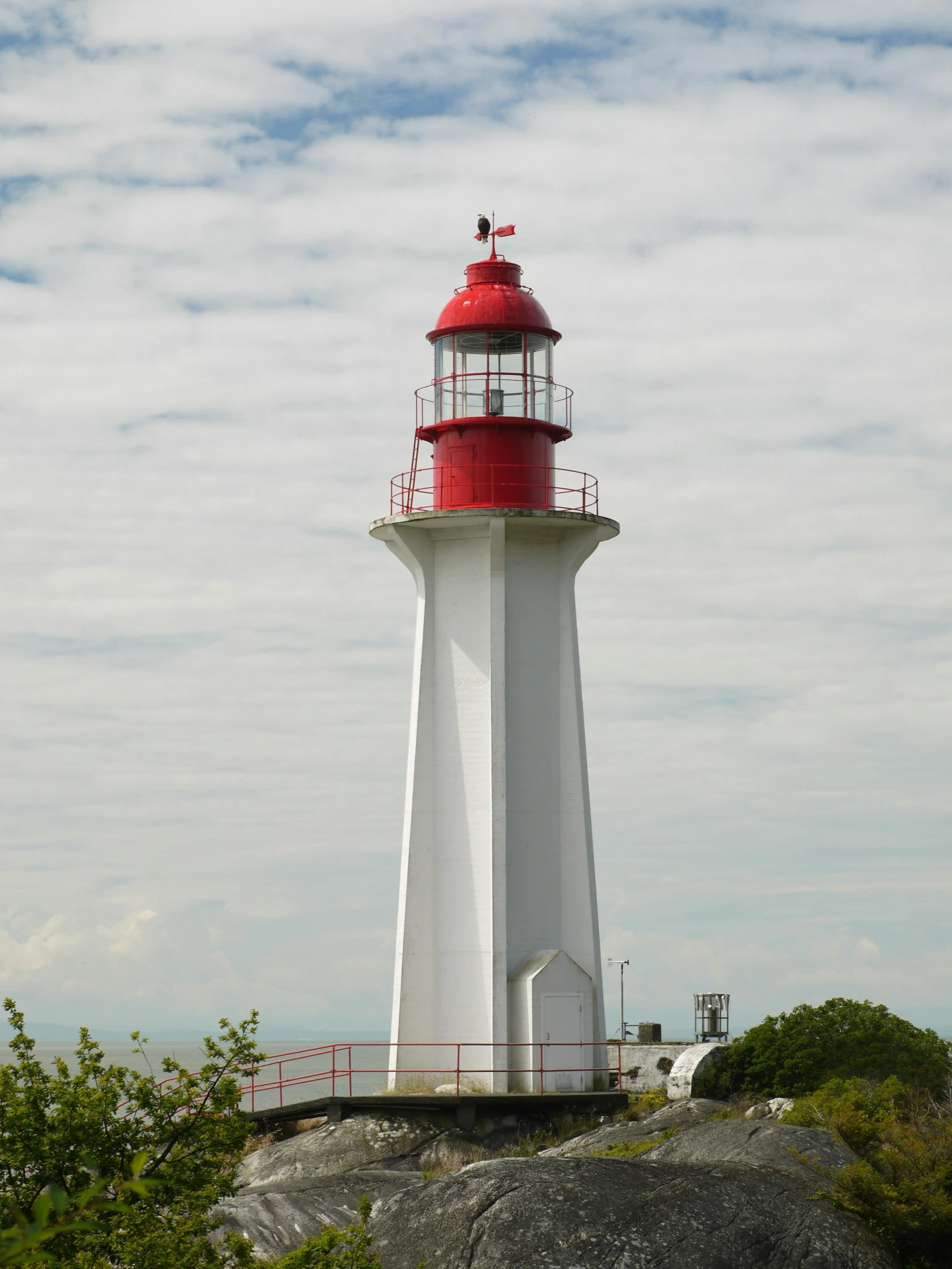 a white and red lighthouse next to the ocean