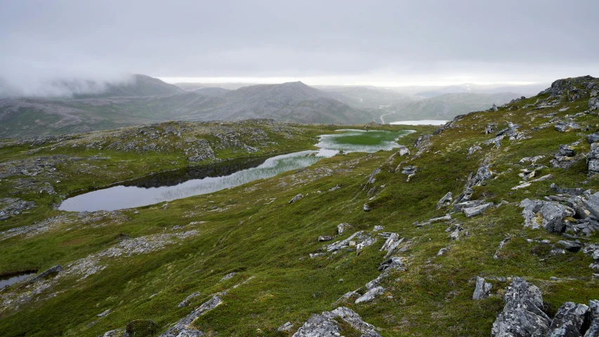 a po taken of a mountaintop shows the low lying grass and water