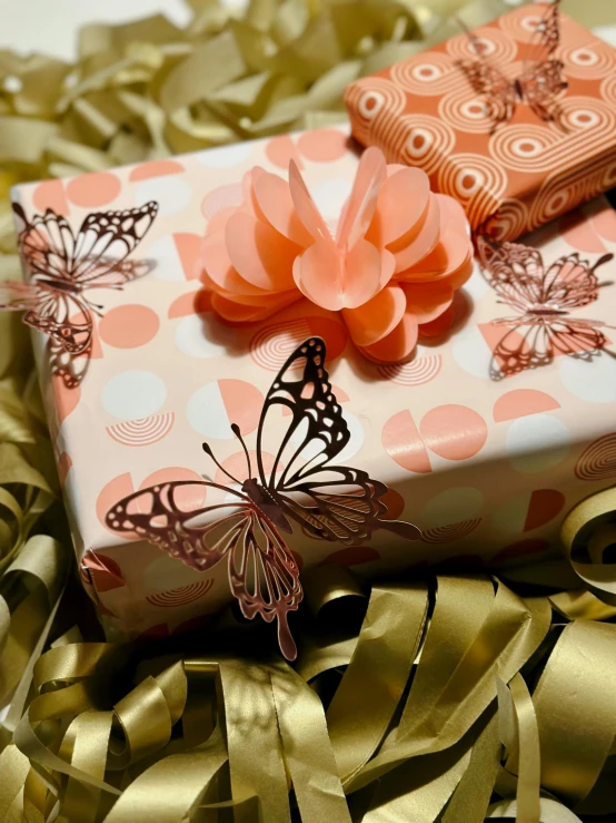 a pink present wrapped in paper with a erfly on it