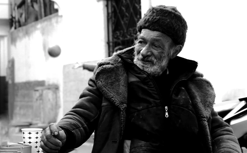 a man wearing a hat stands near a building