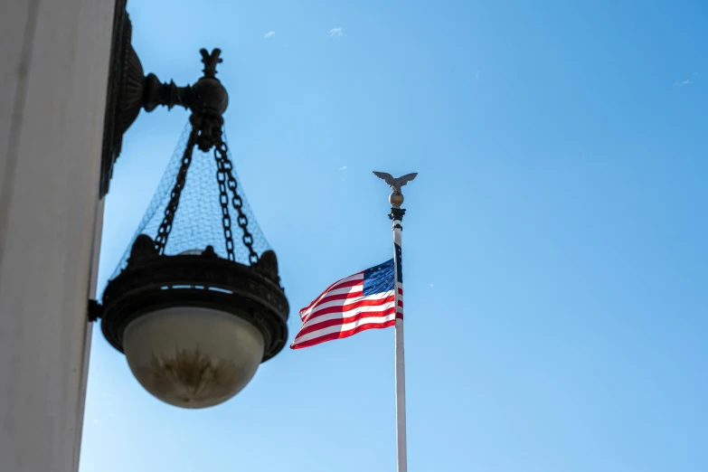 an american flag and a light pole on a street