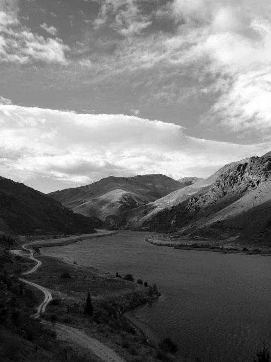 a very scenic po of a river flowing into some hills