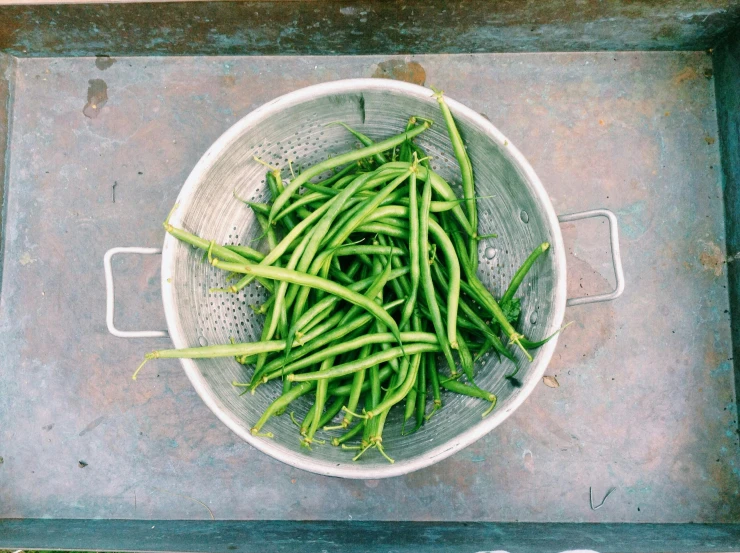 peas being steamed in a bowl over concrete