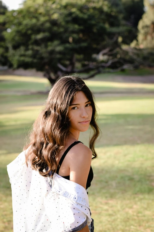 a beautiful woman with long hair posing in the field