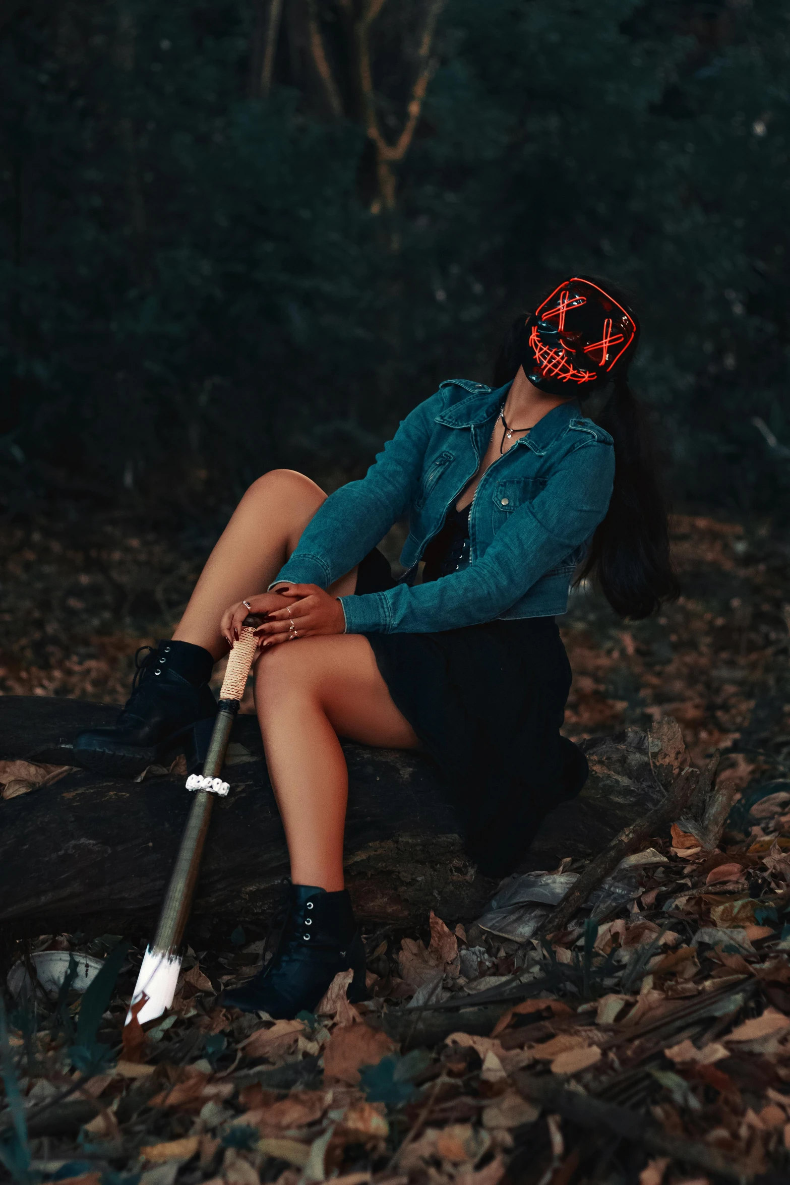 a woman sitting on a log in the woods with her head propped up