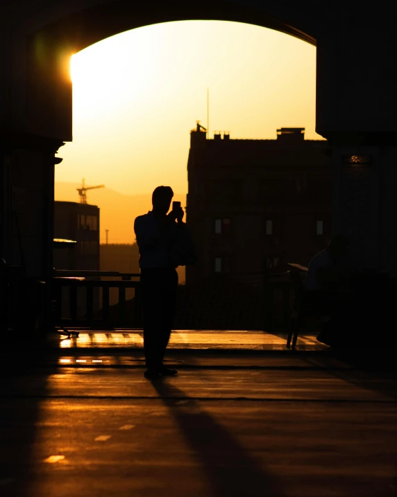 two people are walking away from the sunset