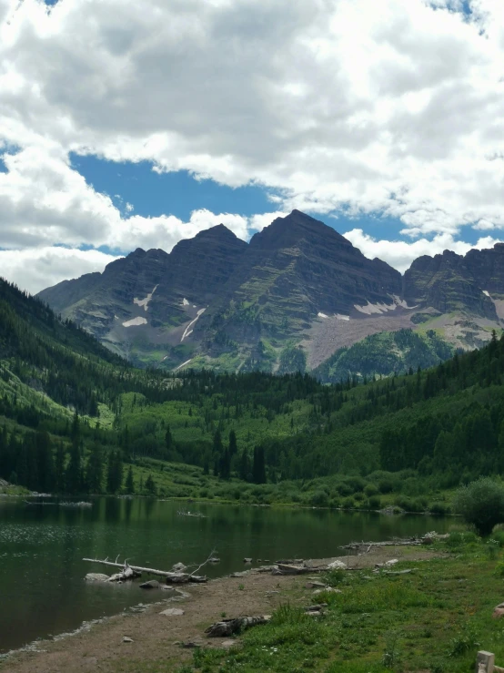 a wide, rocky river runs past the mountains on either side