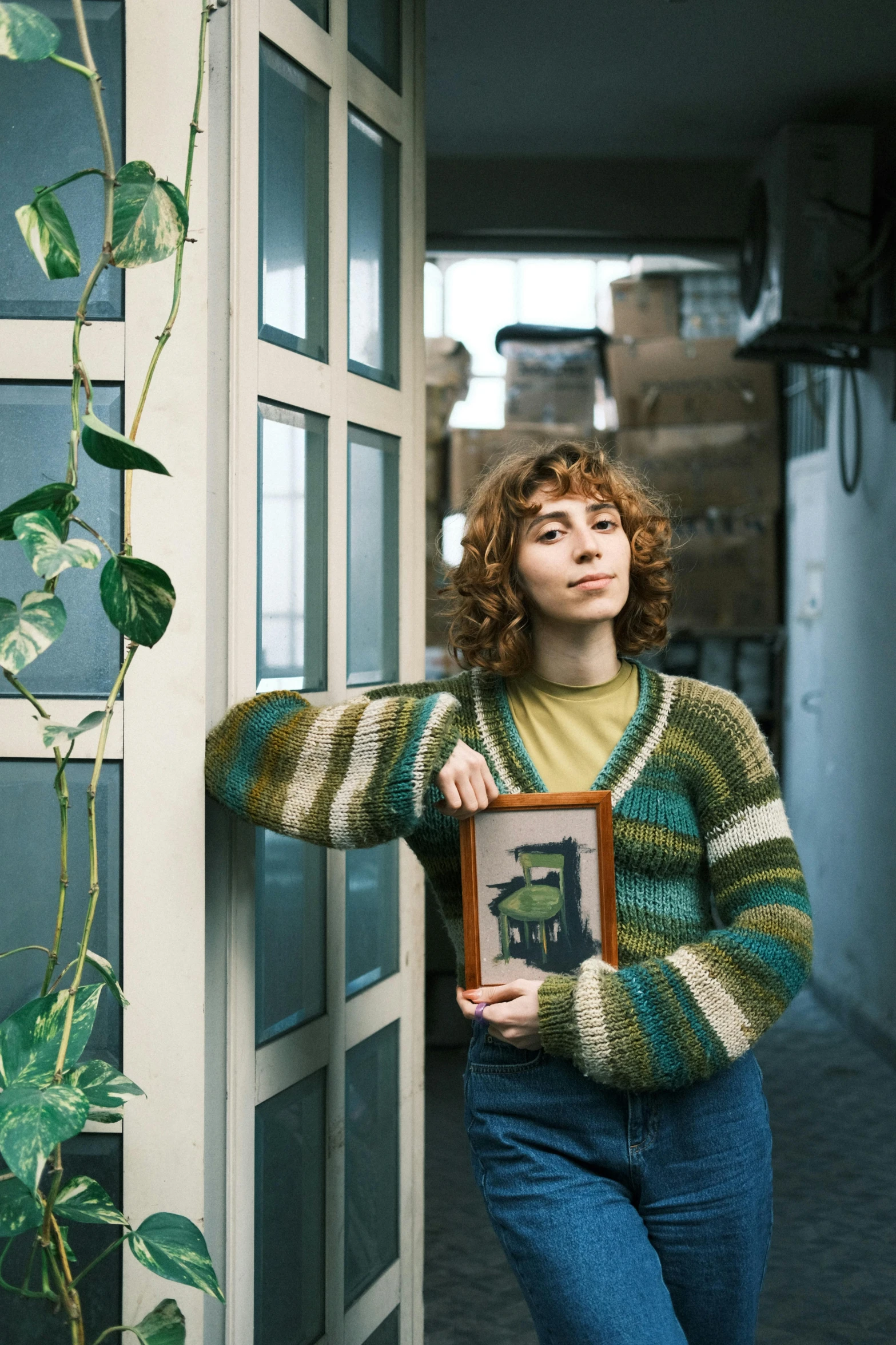 a woman is leaning up against a wall holding a framed pograph