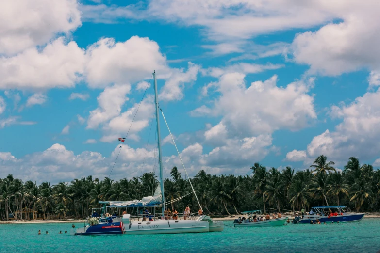 a boat sits in a lagoon with palm trees behind it