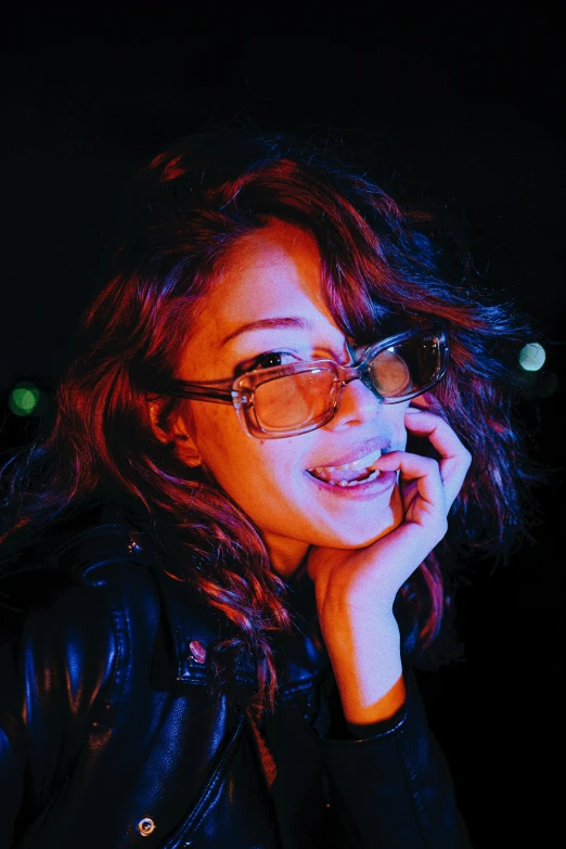 a young woman wearing glasses looks to the side with her head to the side