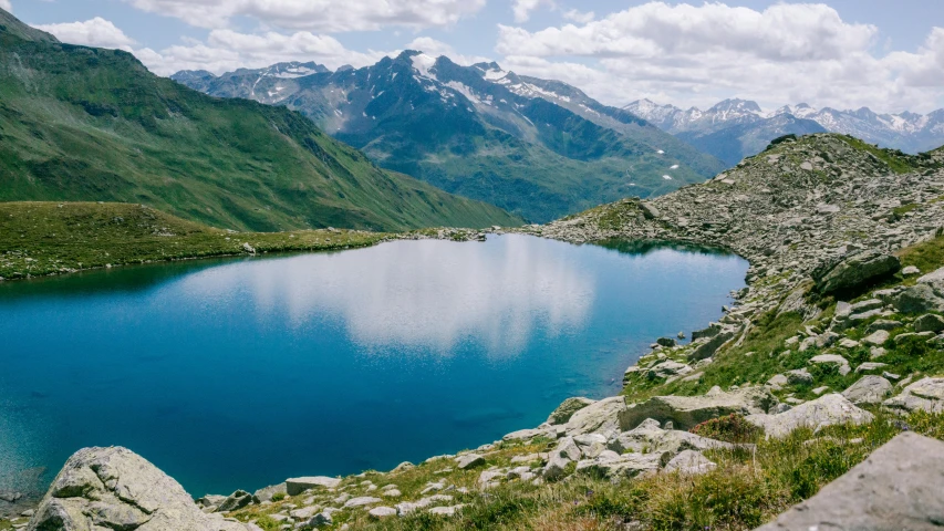 a small lake in a rocky area on the side of a mountain