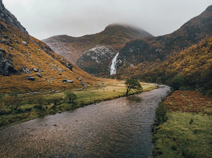 a valley with a mountain waterfall next to it