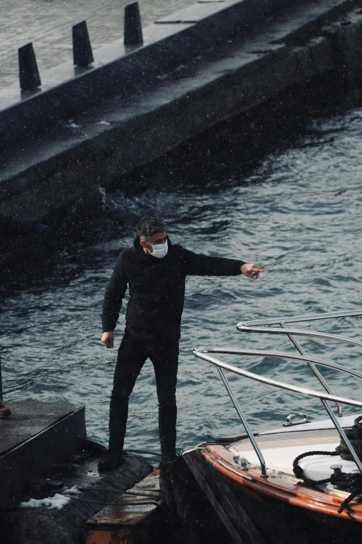 a man standing on a pier with his hand out