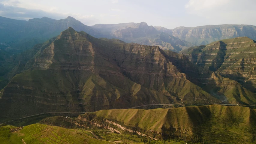 a mountain view with a winding road surrounded by green hills