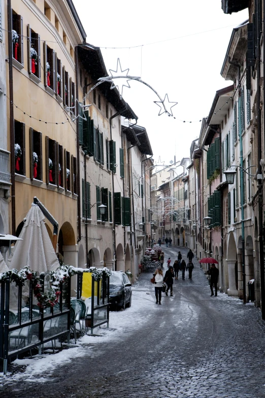 people are standing in an alley in an old town