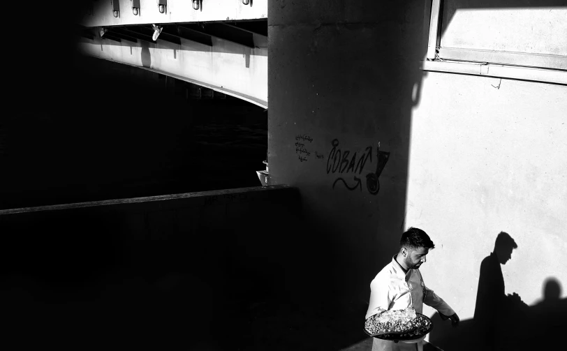 a man is standing by the wall while looking at his phone