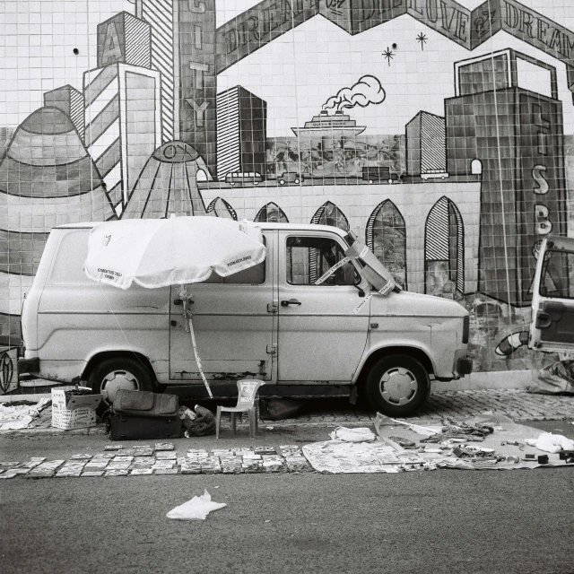 a van parked outside a painting depicting a large boat