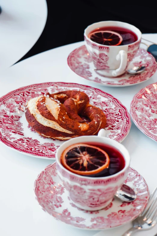 two cups on a table with plates and saucers