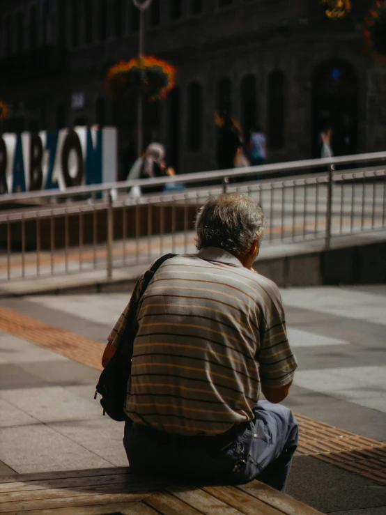 a man with a back pack sits on the side walk