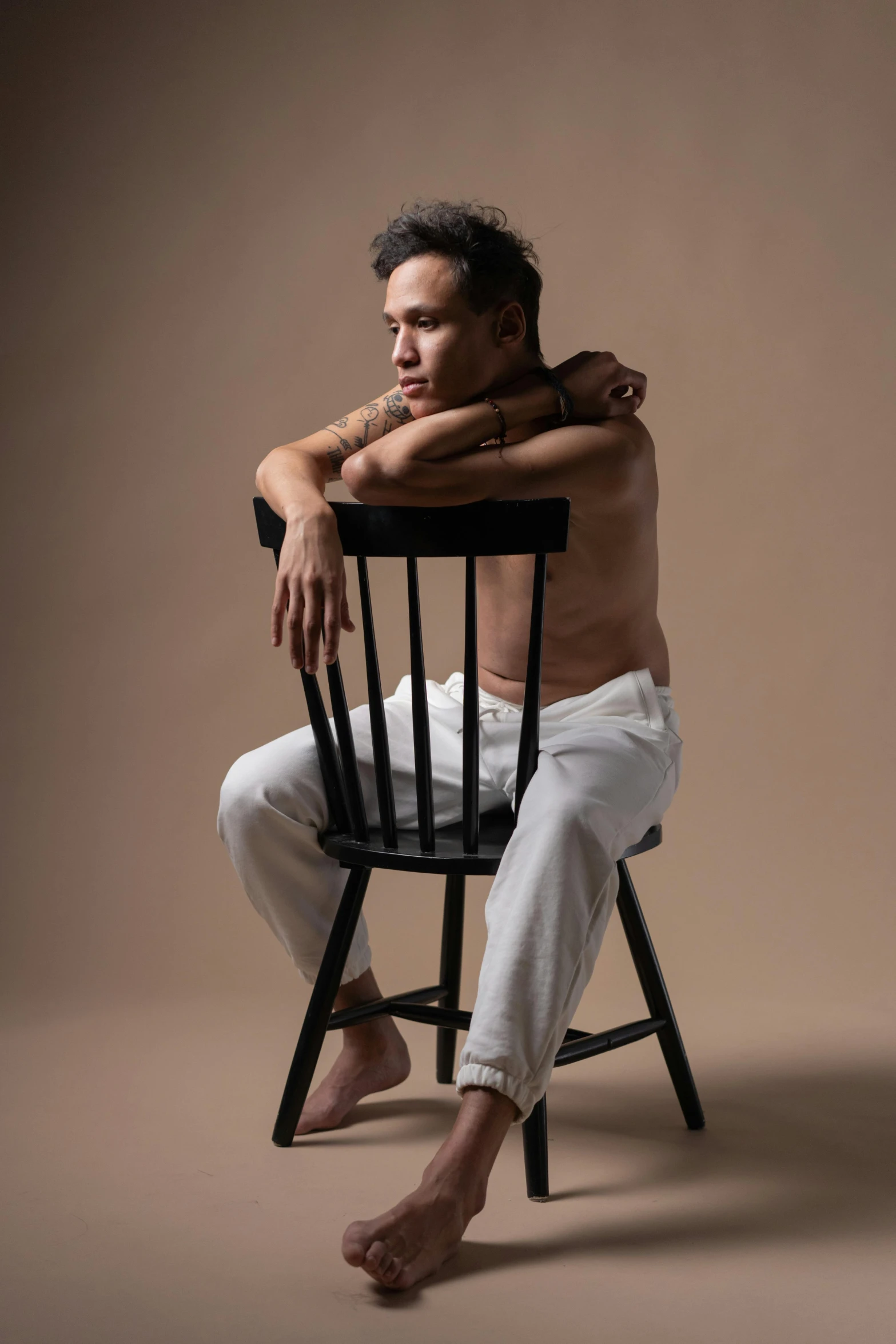 a man sitting in a chair next to his back with a tattoo on