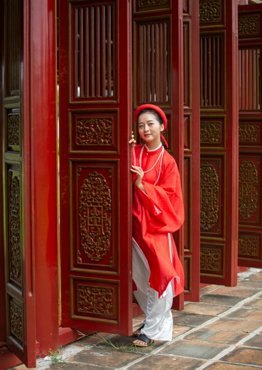 a woman wearing an oriental outfit posing with an oriental style doorway