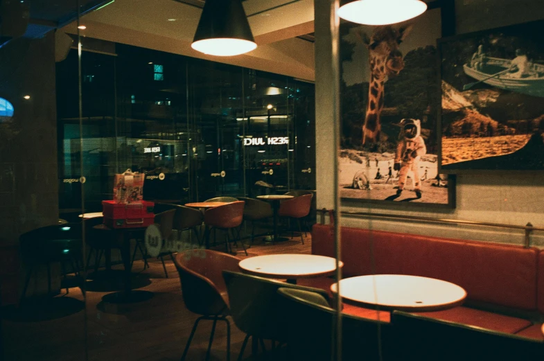 a restaurant with an enclosed bar, round tables and chairs