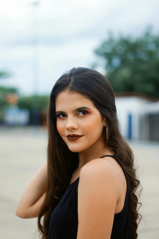 a girl wearing a black shirt poses with her hair up