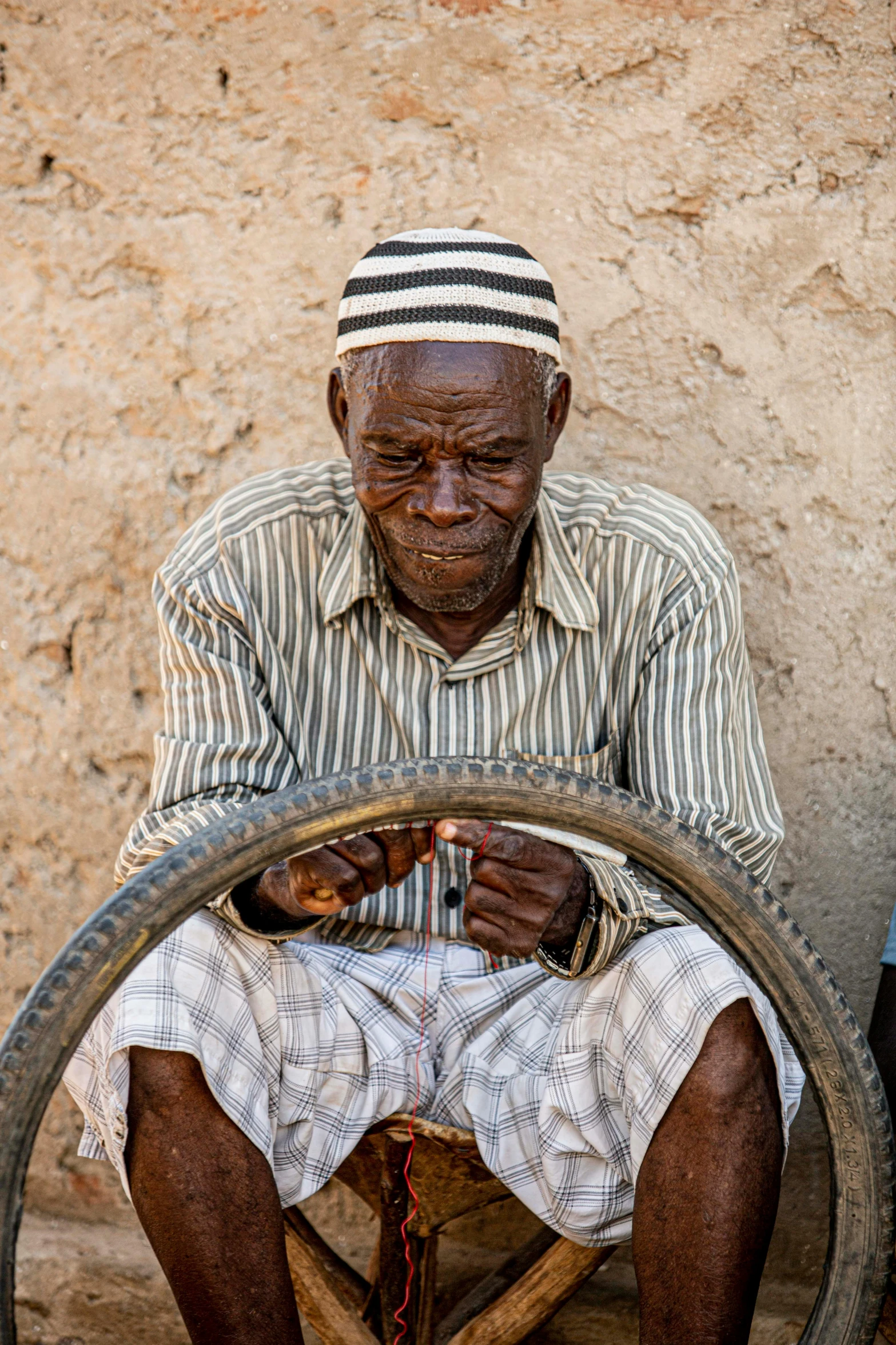 man using spinning wheel to hold soing while seated