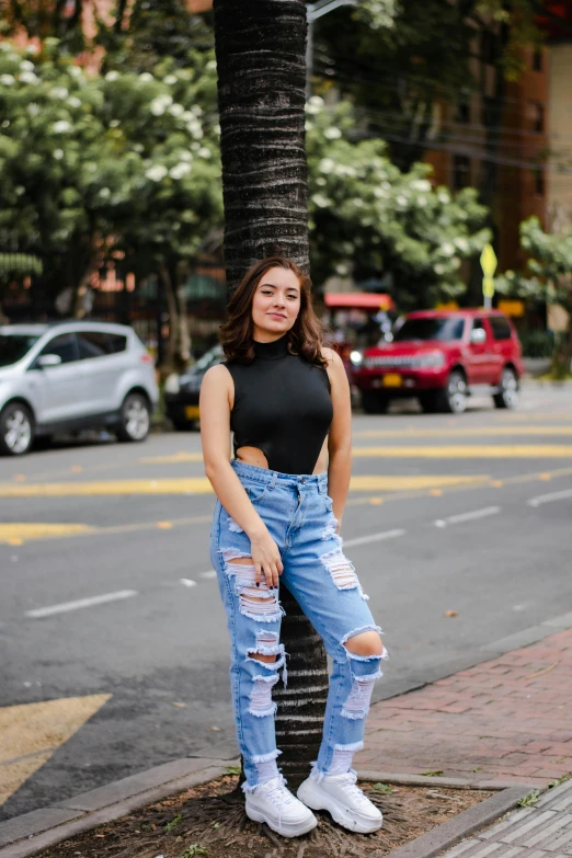 a woman with black top and jean pants posing for a po