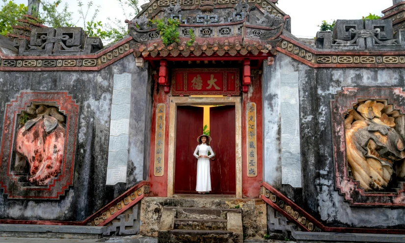 a woman standing in front of an entrance to a temple