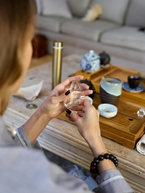 woman sitting on couch looking at a glass container