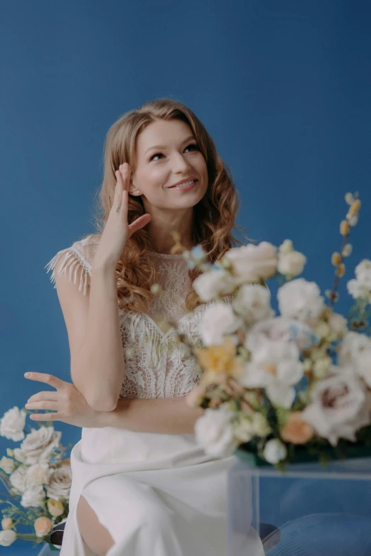 a woman posing for a po near a flower vase