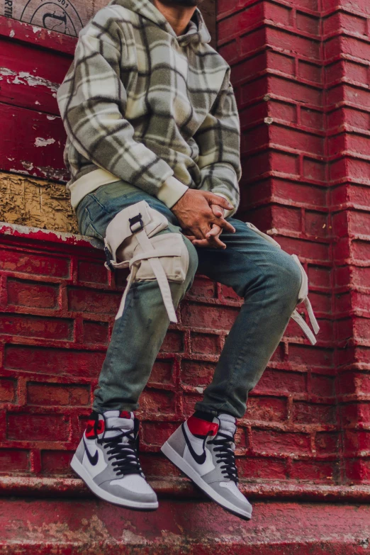 a man is sitting on top of a wall with his foot in the air