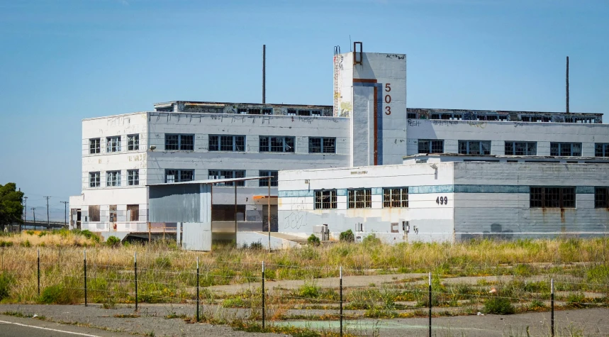 an empty, rundown industrial building in a field