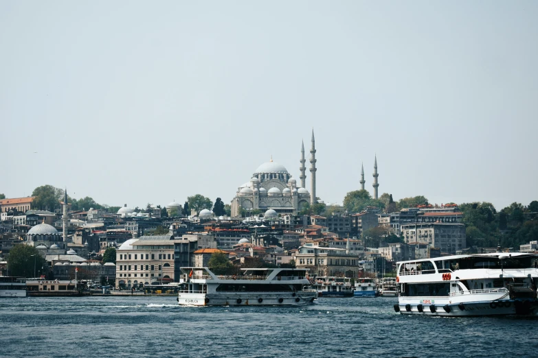 a boat is traveling in the ocean past some city buildings