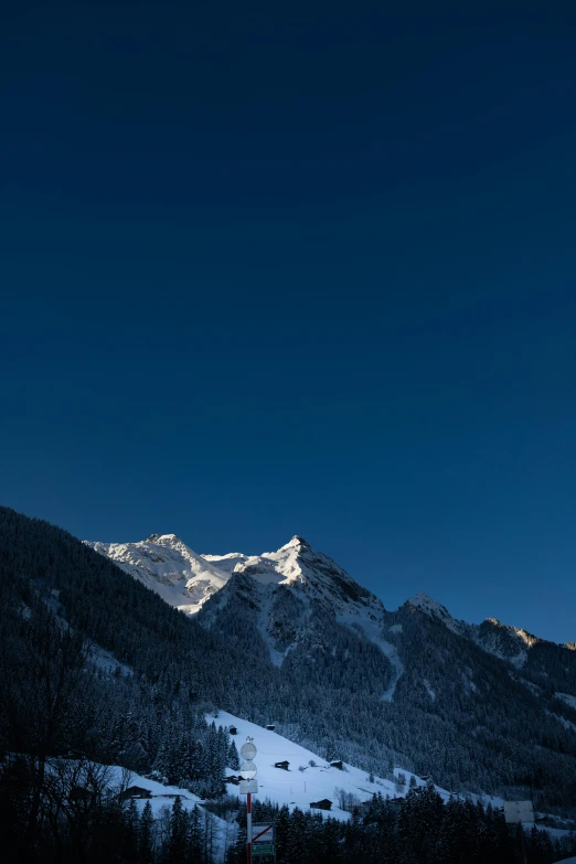 a mountain view with snow and the moon in the sky